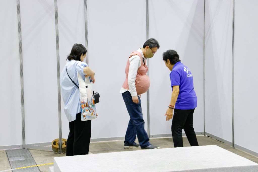 パートナーが妊婦体験用のベストを試している様子