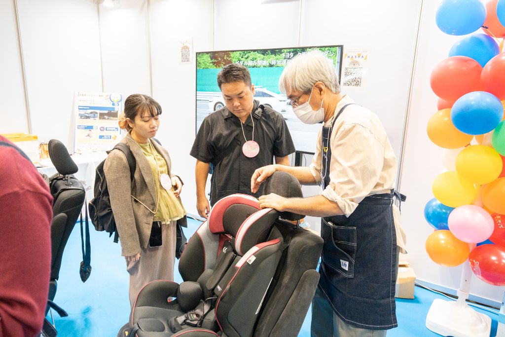 チャイルドシートなど出産準備アイテムを見ている来場者の様子